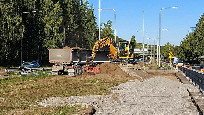 Kaivuri ja kuorma-auto Paasikiventien varrella lisäkaistan rakennustyömaalla.