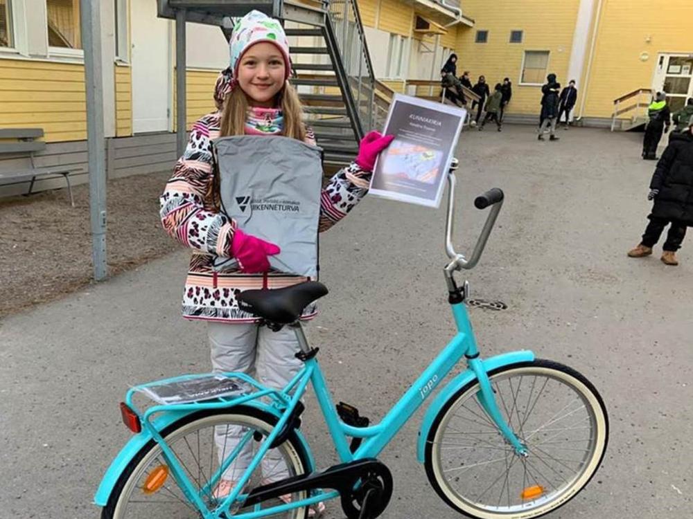 Karolina poseeraa kuvassa palkintopolkupyörän kanssa. 