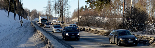 Autoja ajamassa talvisella tiellä.