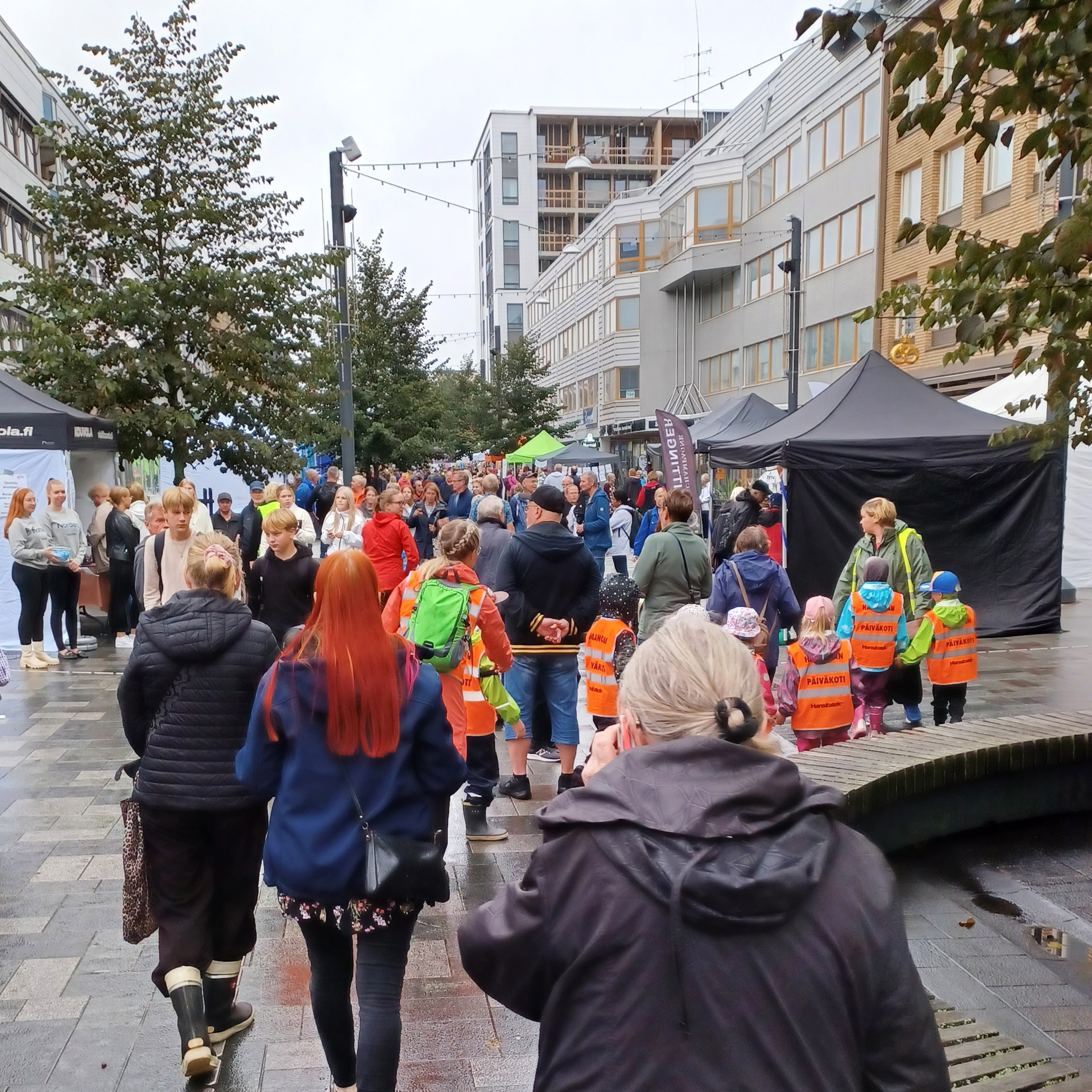 Takaapäin otettu kuva ihmisistä jotka ovat Kouvolan kävelykatu Manskilla. 