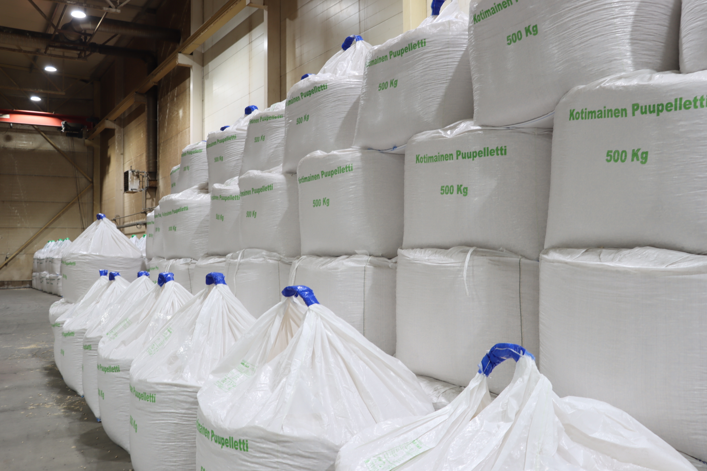 Kotimainen Puupelletti 500 kg säkkejä siistissä järjestyksessä tehdastiloissa.