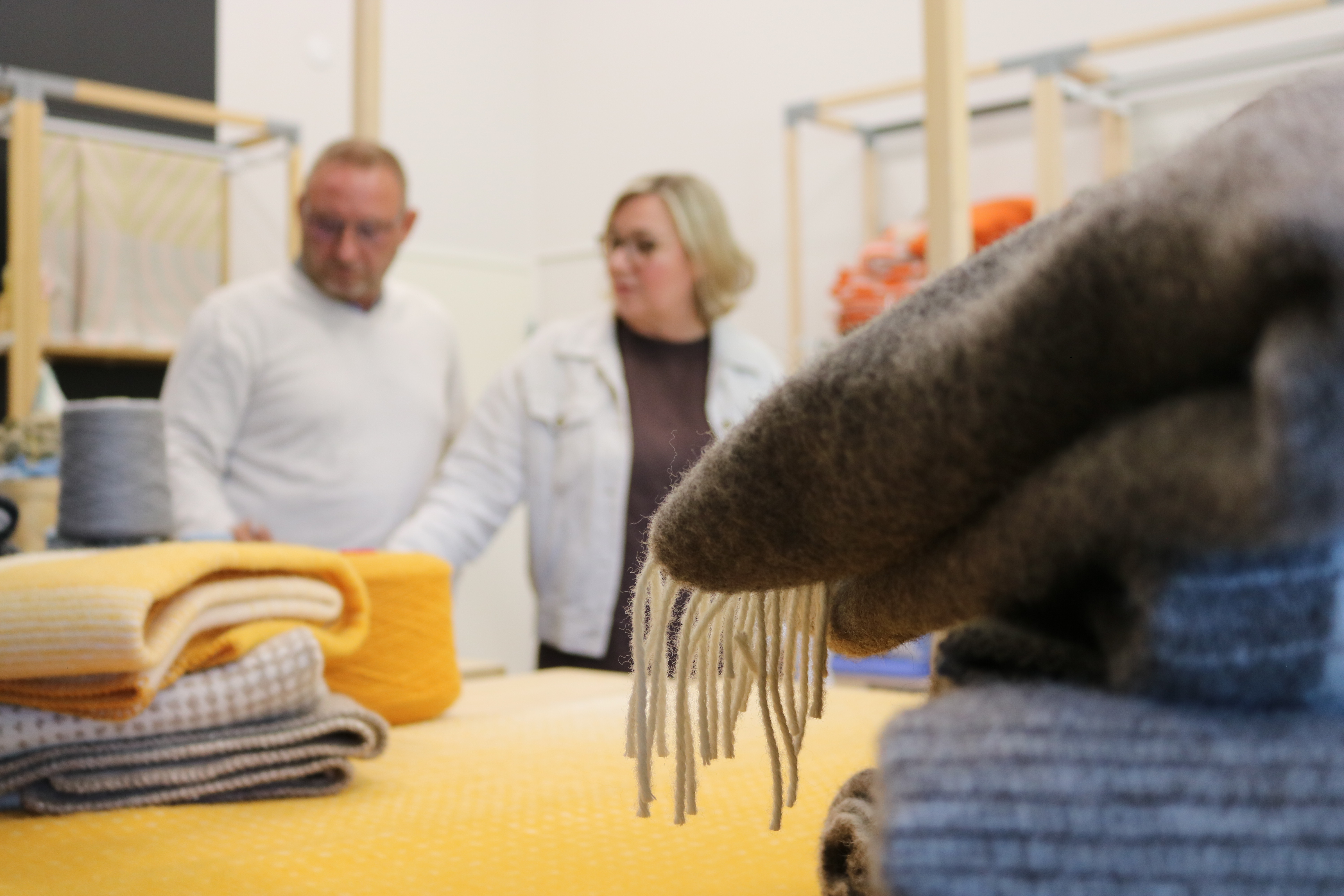 Työpöytä, jossa villavilttejä. Taustalla Esko ja Jaana Hjält.