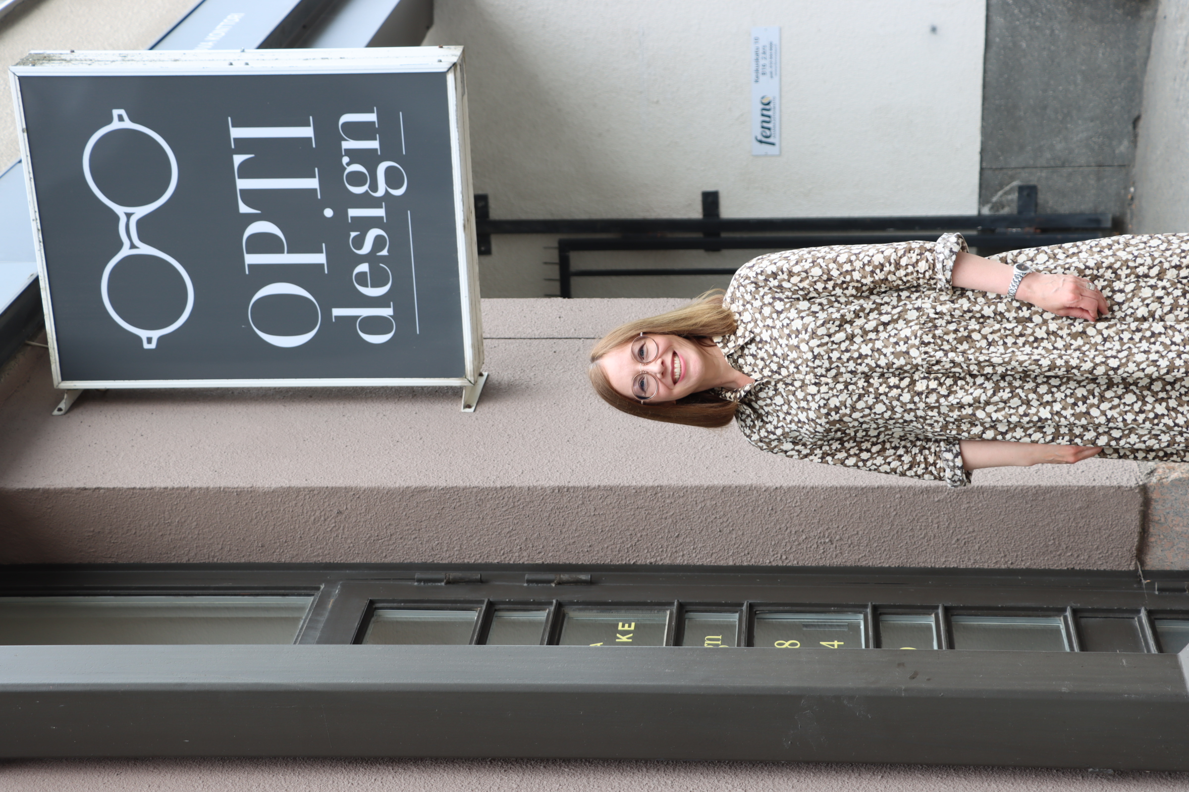 Yrittäjä Ulla Alatalo Opti-Design kyltin alla.