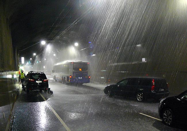 Pelastusharjoitus Rantatunnelissa. Linja-auto, henkilöautoja, vesisadetta hämärässä tunnelissa.