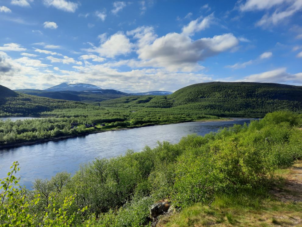 Tenojokilaakson maisemaa. Kuvassa joki ja takana tuntureita.