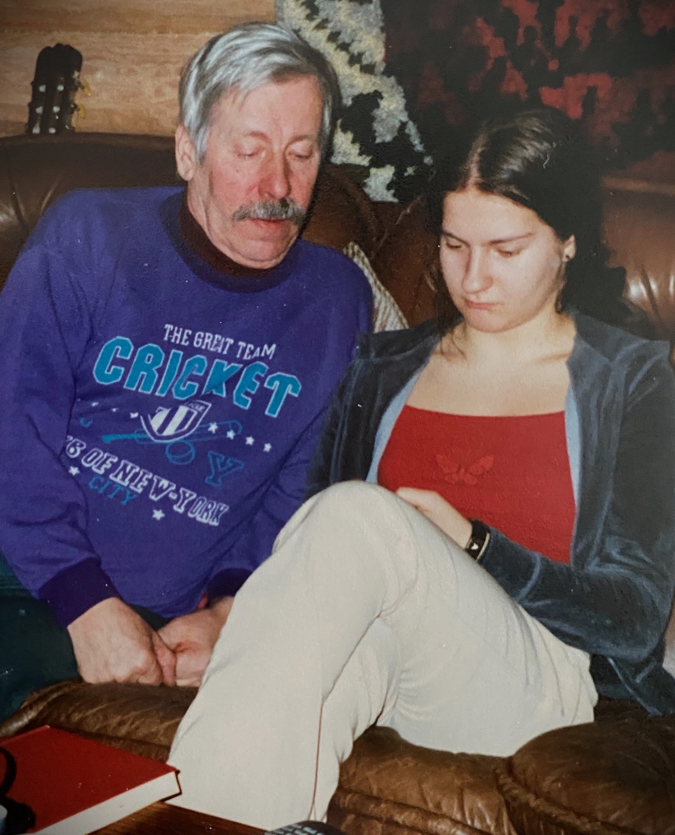 Valokuvassa sohvalla istumassa Tiina Lindström nuorena ja hänen isoisänsä. Tiina ja isoisä katsovat kännykkää.